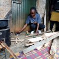 Burn company enumerator Teresia Wanjiru checks moisture on firewood in Kachoroba village of Kiambu county