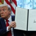 President Donald Trump holds a signed executive order in the Oval Office at the White House in Washington, D.C., U.S., April 23, 2025. REUTERS/Leah Millis. Trump's first 100 days: US walks away from global climate action