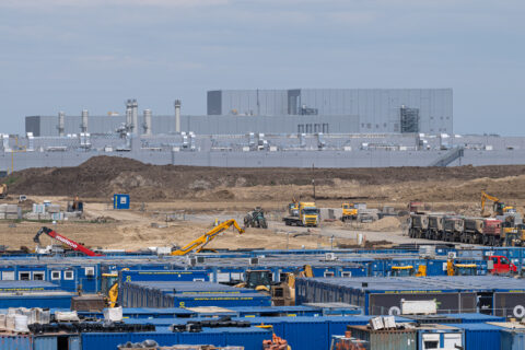 Containers and a crane in front of CATL's EV battery factory under construction in Hungary