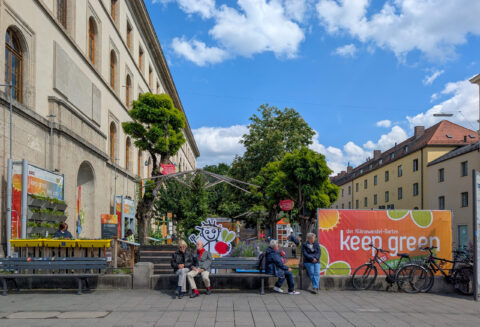 People sit and rest near the climate garden installation ''Keep Green - Der Klimawandel-Garten'' during the Zamanand Festival outside the university buildings on Ludwigstrasse in Munich, Bavaria, Upper Bavaria, Germany