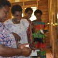 Women test a solar installation in Lawital, Vanuatu