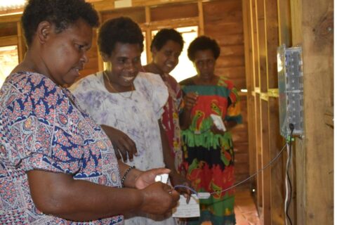 Women test a solar installation in Lawital, Vanuatu
